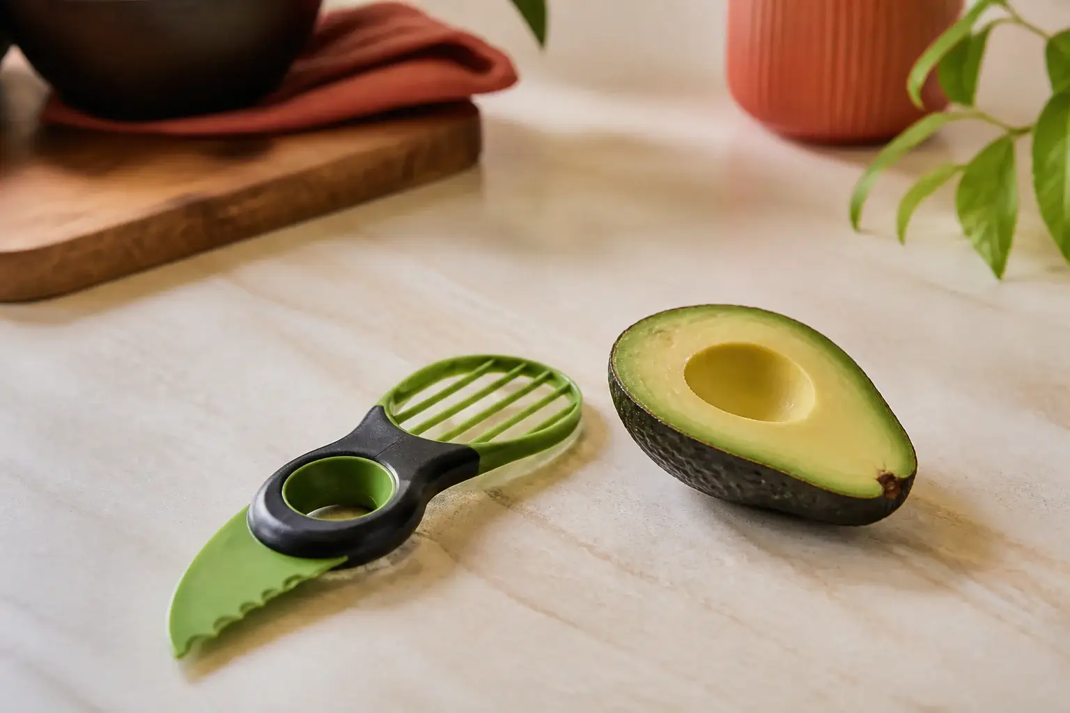 Utensilio genérico para aguacate junto a un aguacate abierto y sin hueso